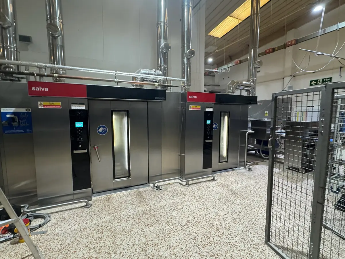 Two Salva rack ovens with stainless steel flues in a bakery production area