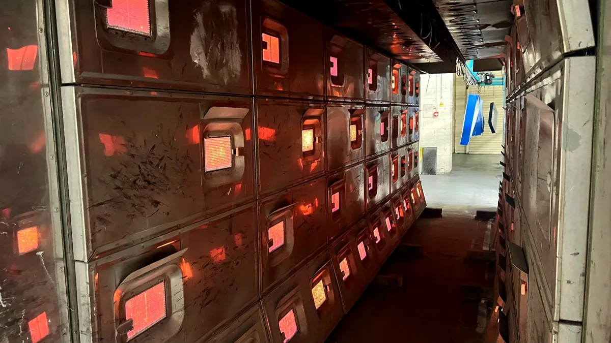 Rows of glowing gas-fired infrared panels lining both walls of an industrial drying tunnel