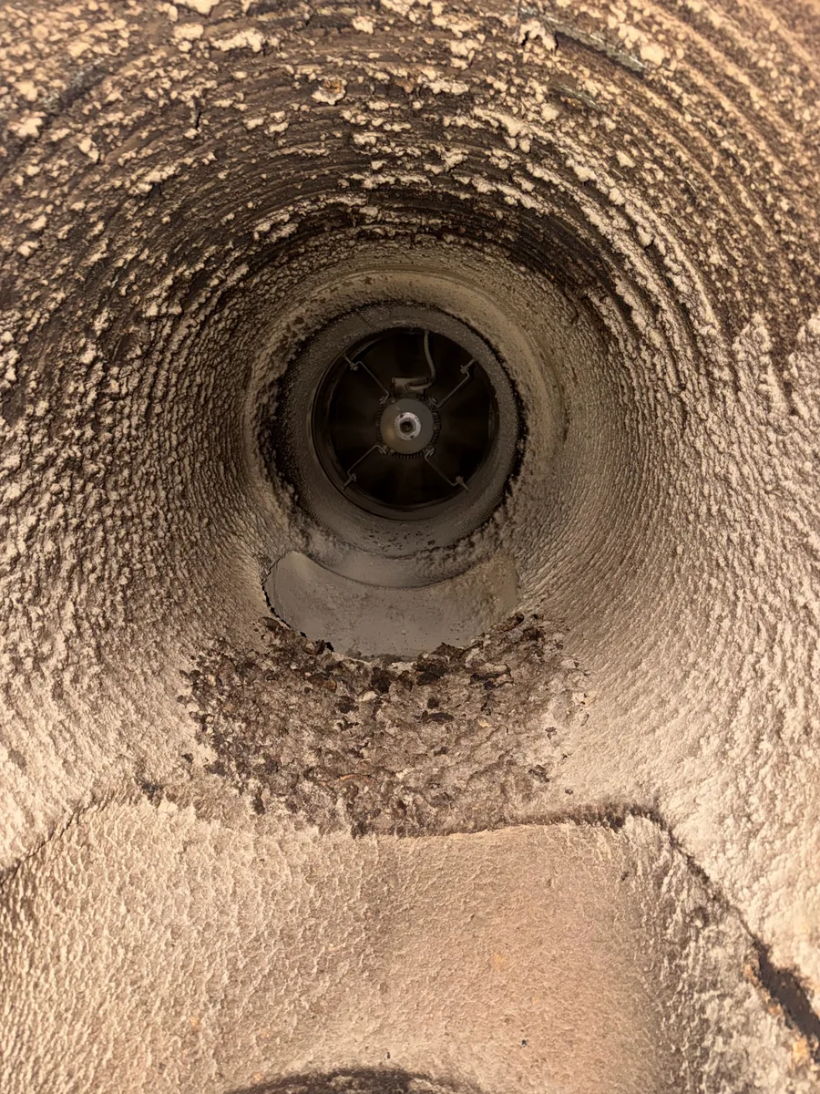 Dust and debris built up inside factory extract duct and fan before cleaning