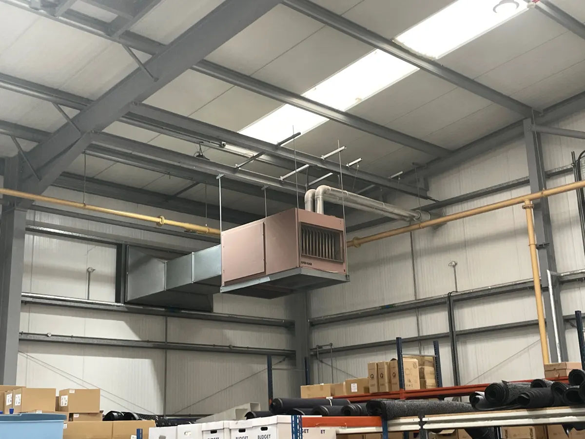 Gas-fired warm air heater with ducting in a warehouse in Lancaster