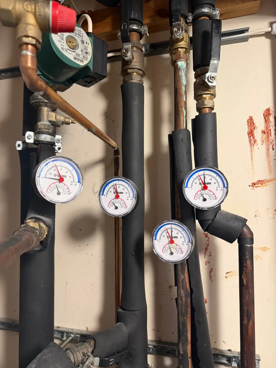 Plant room pipework with circulating pump and four pressure and temperature gauges, Preston