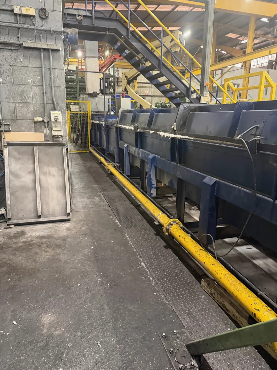 Long gas-fired process line with yellow gas main running alongside, Wigan